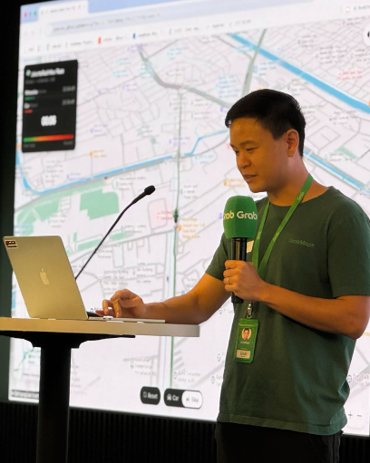 Chip on stage presenting the GrabMaps MCP demo, with a map on the screen behind him